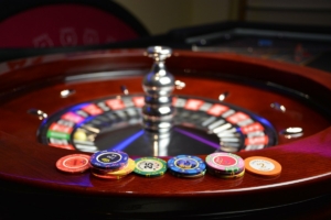 Roulette wheel with casino chips on top of it.