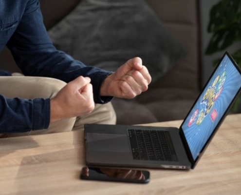 Man with clenched fists at laptop on table