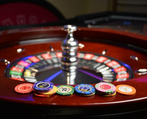 Roulette wheel with casino chips on top of it.