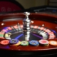 Roulette wheel with casino chips on top of it.