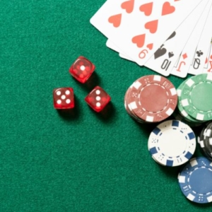 dice and poker chips on a casino table next to cards facing up