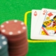 an ace and a queen on a green blackjack table next to blackjack chips